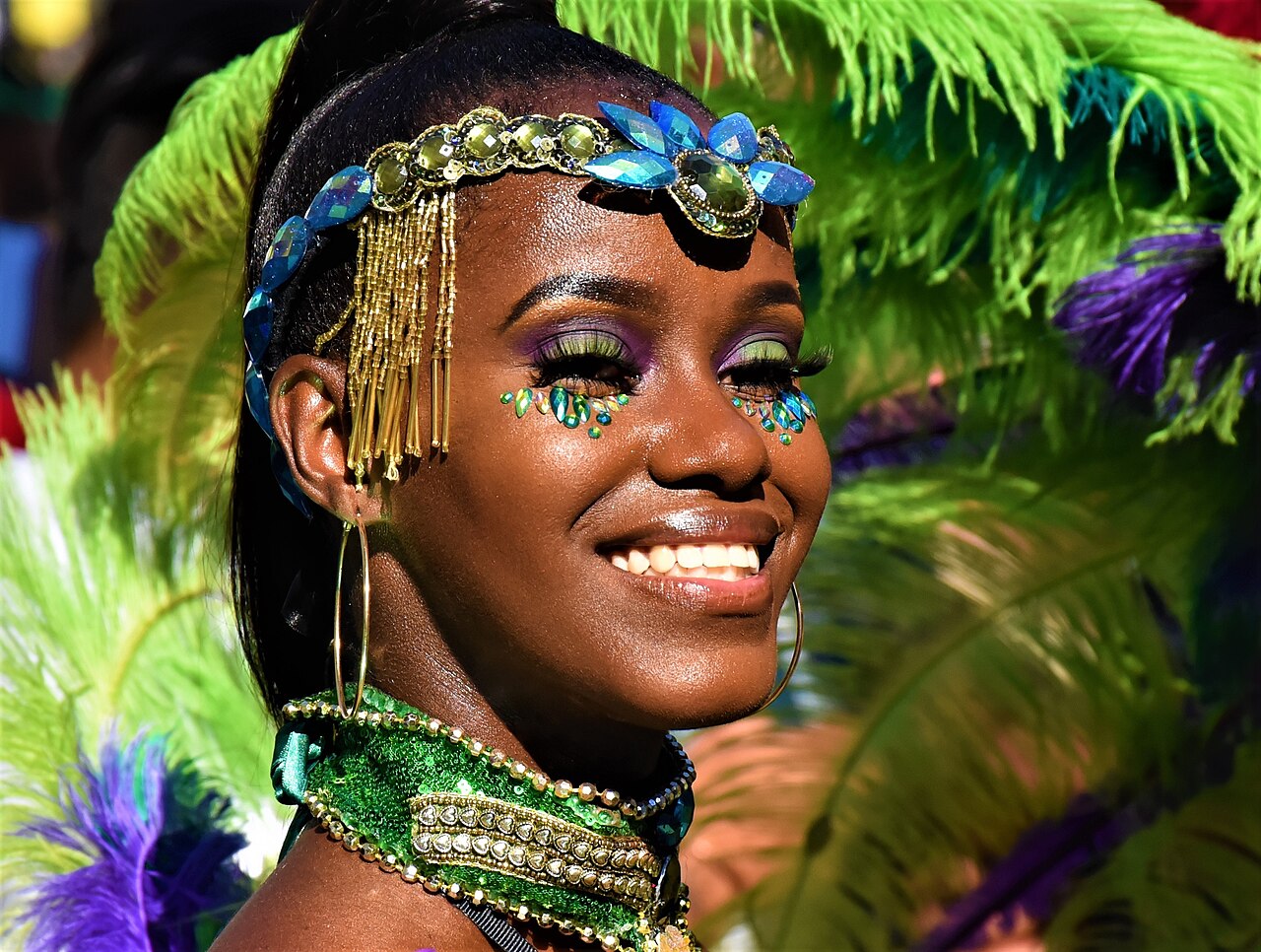 A Carnival participant wearing a jewelled headpiece with green feathers, Notting Hill, 2019.