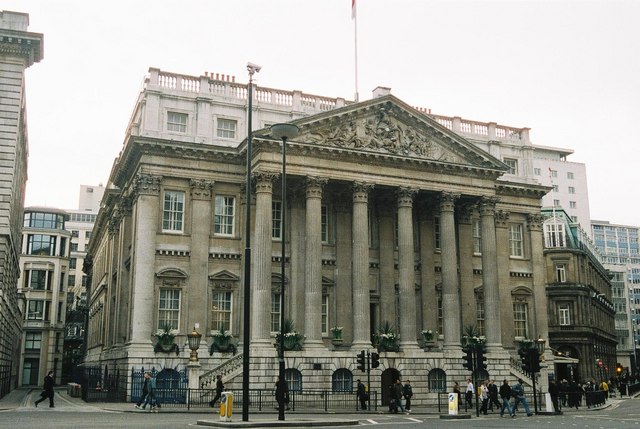 The columned front of Mansion House in the City of London, with pedestrians in front.