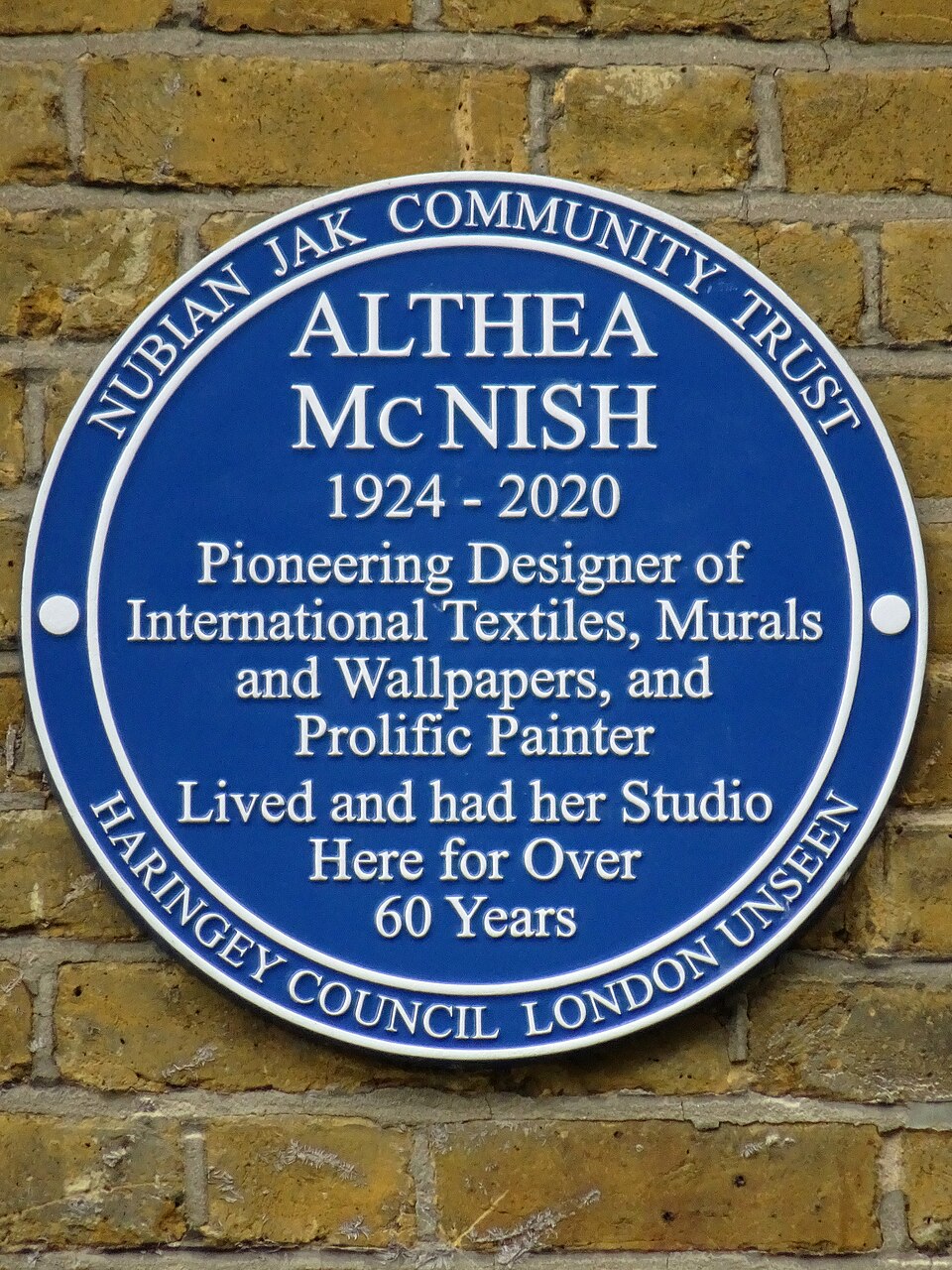 A blue plaque commemorating Althea McNish at her former home and studio.