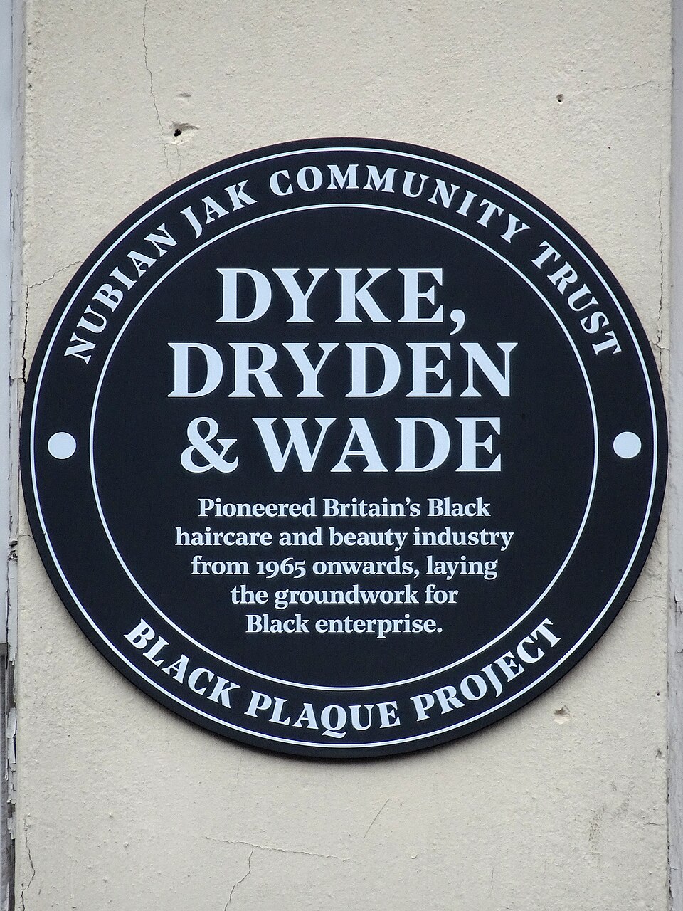 A black plaque commemorating Dyke, Dryden and Wade’s pioneering haircare and beauty business.